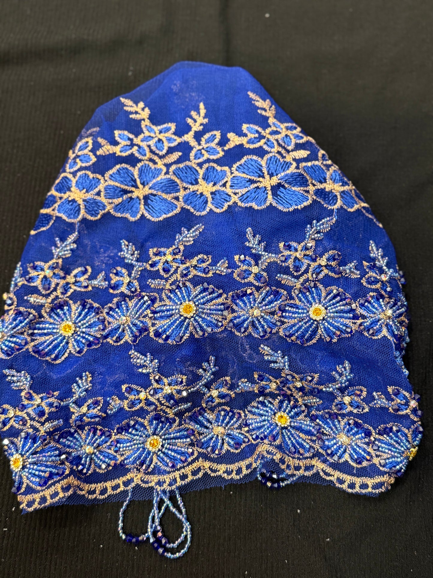 Blue lace hijab cap flat lay with embellished floral pattern