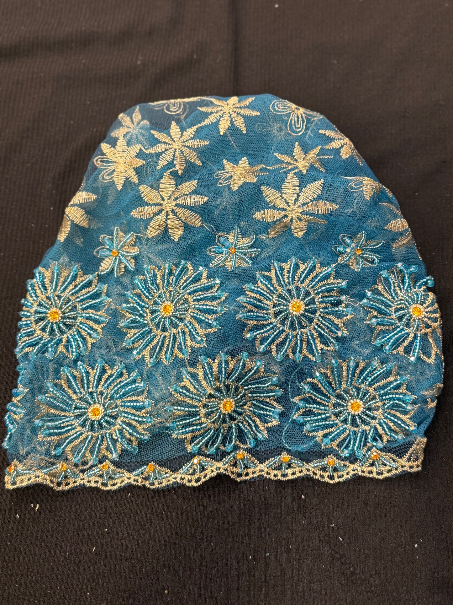 Blue lace hijab cap flat lay with embellished floral pattern