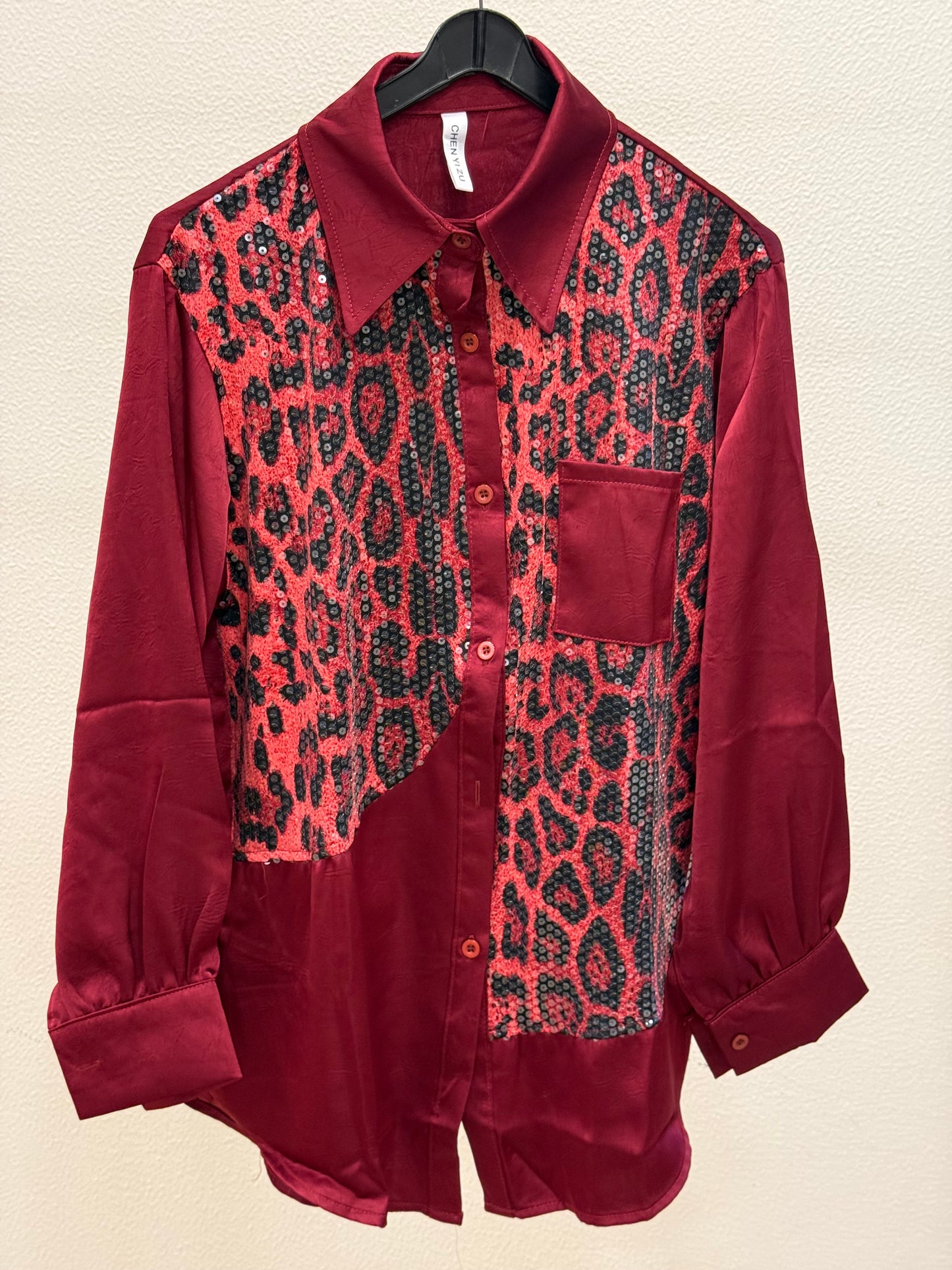 Red satin shirt with sequin leopard print panel and chest pocket on hanger