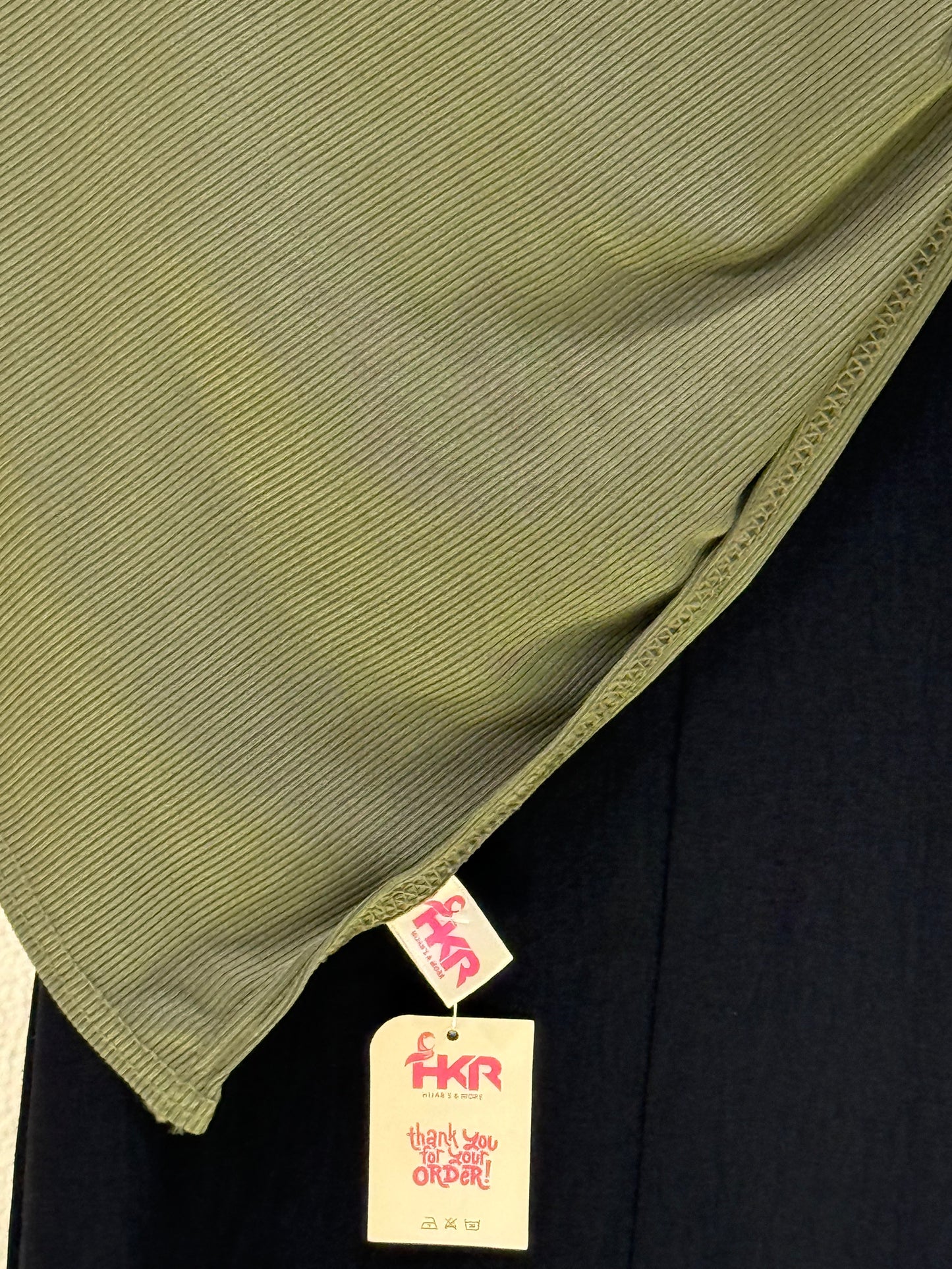 Premium dark green jersey hijab close-up showcasing stretch fabric texture