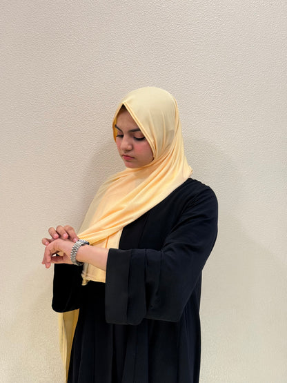 Premium jersey mustard hijab with soft stretch fabric, lightweight feel, and elegant modest styling for daily wear.