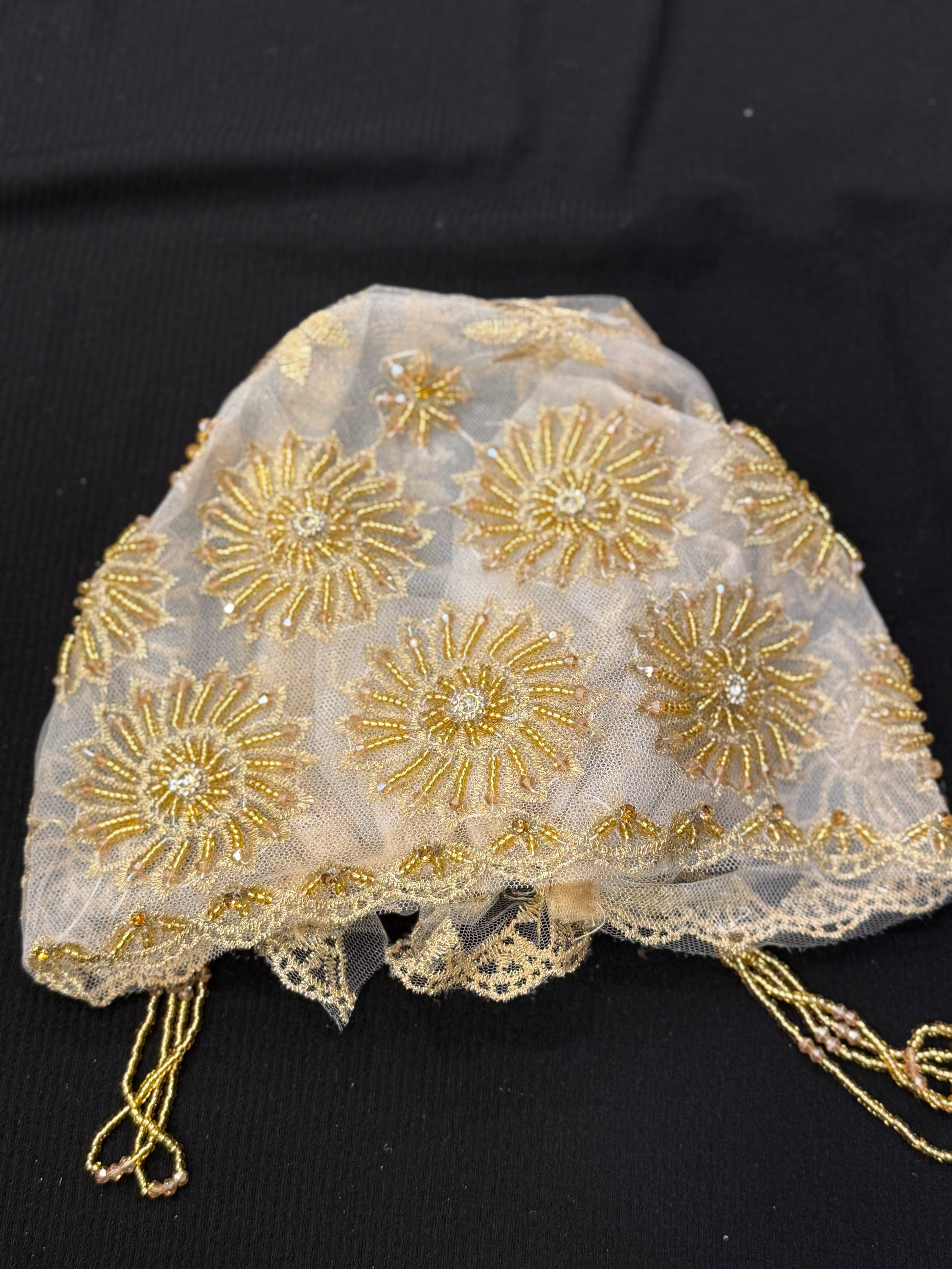 White and gold lace hijab cap flat lay with embellished floral pattern