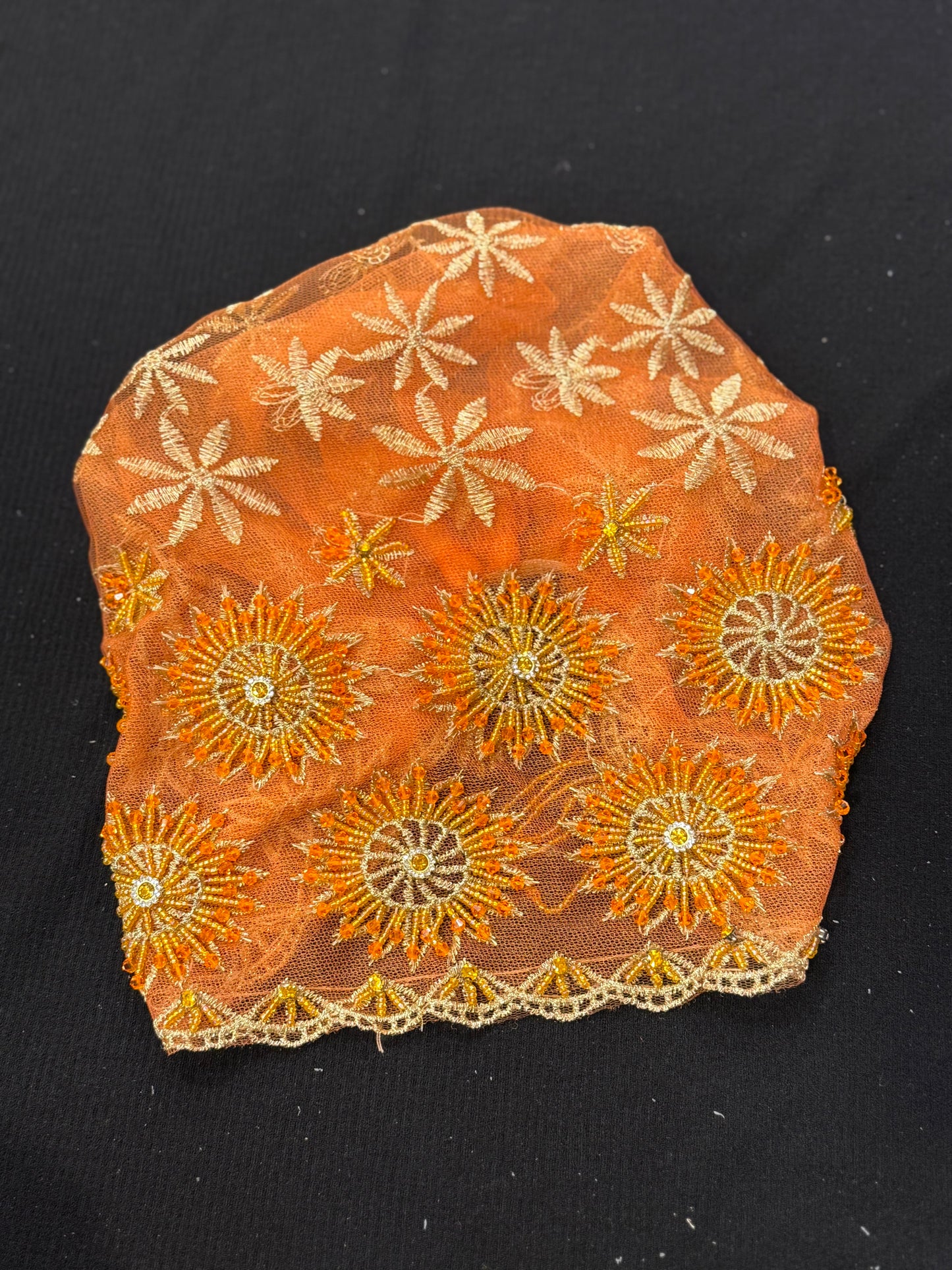Orange lace hijab cap flat lay with embellished floral pattern