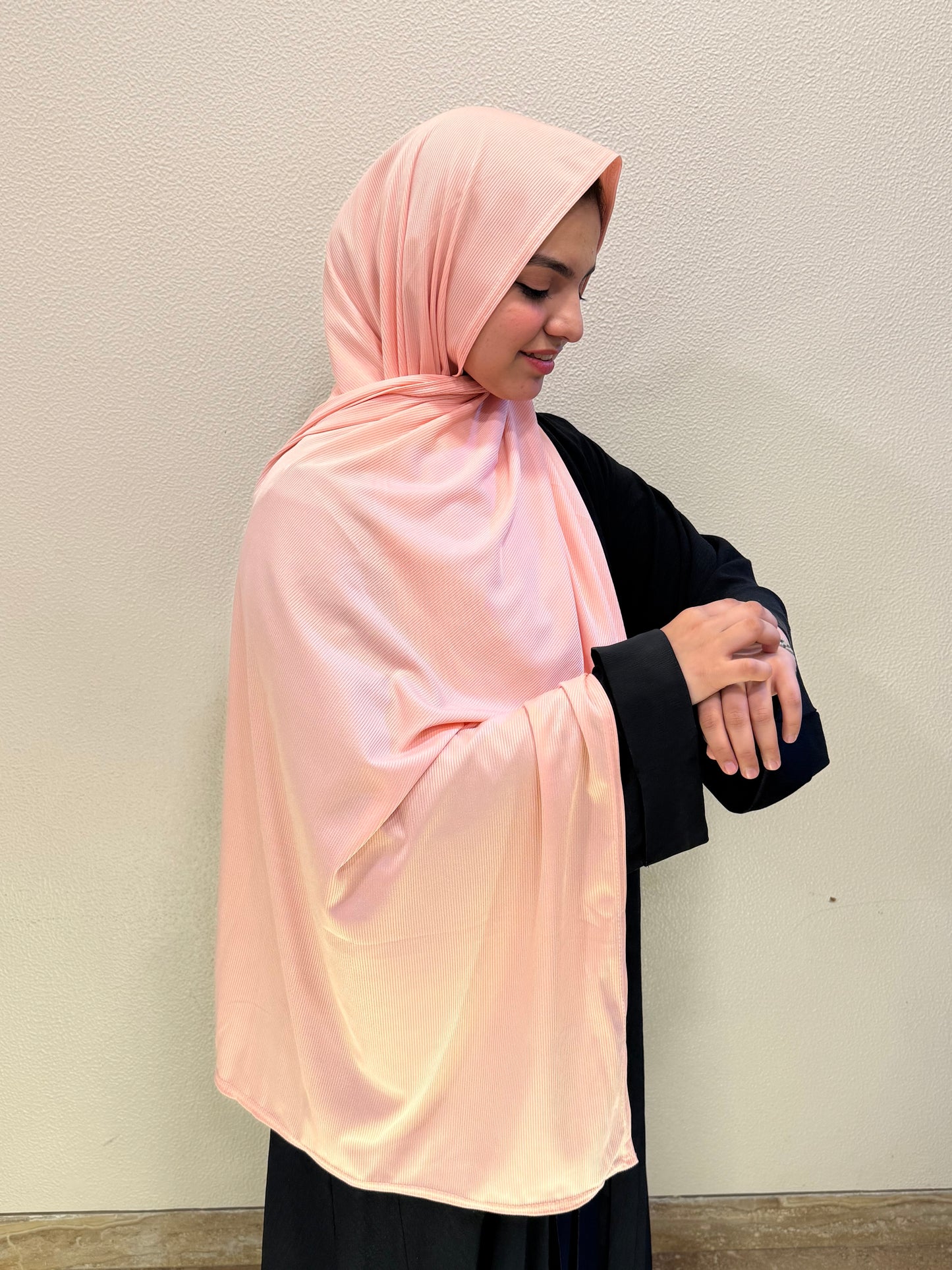 Premium jersey peach pink hijab with soft ribbed texture, breathable stretch fabric, and elegant drape for stylish modest wear.