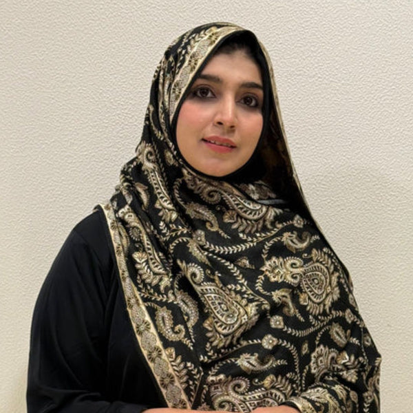 Woman wearing black paisley printed pashmina shawl hijab with blue and gold pattern