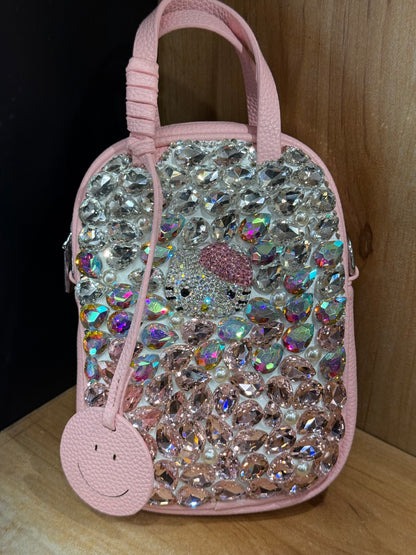 Pink pebbled vegan leather mini handbag with top handles and crossbody strap, back view